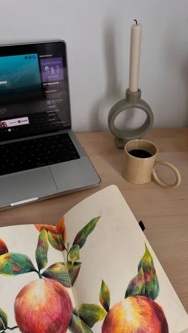 Person browsing the web on a MacBook at a wooden desk with a smartphone.